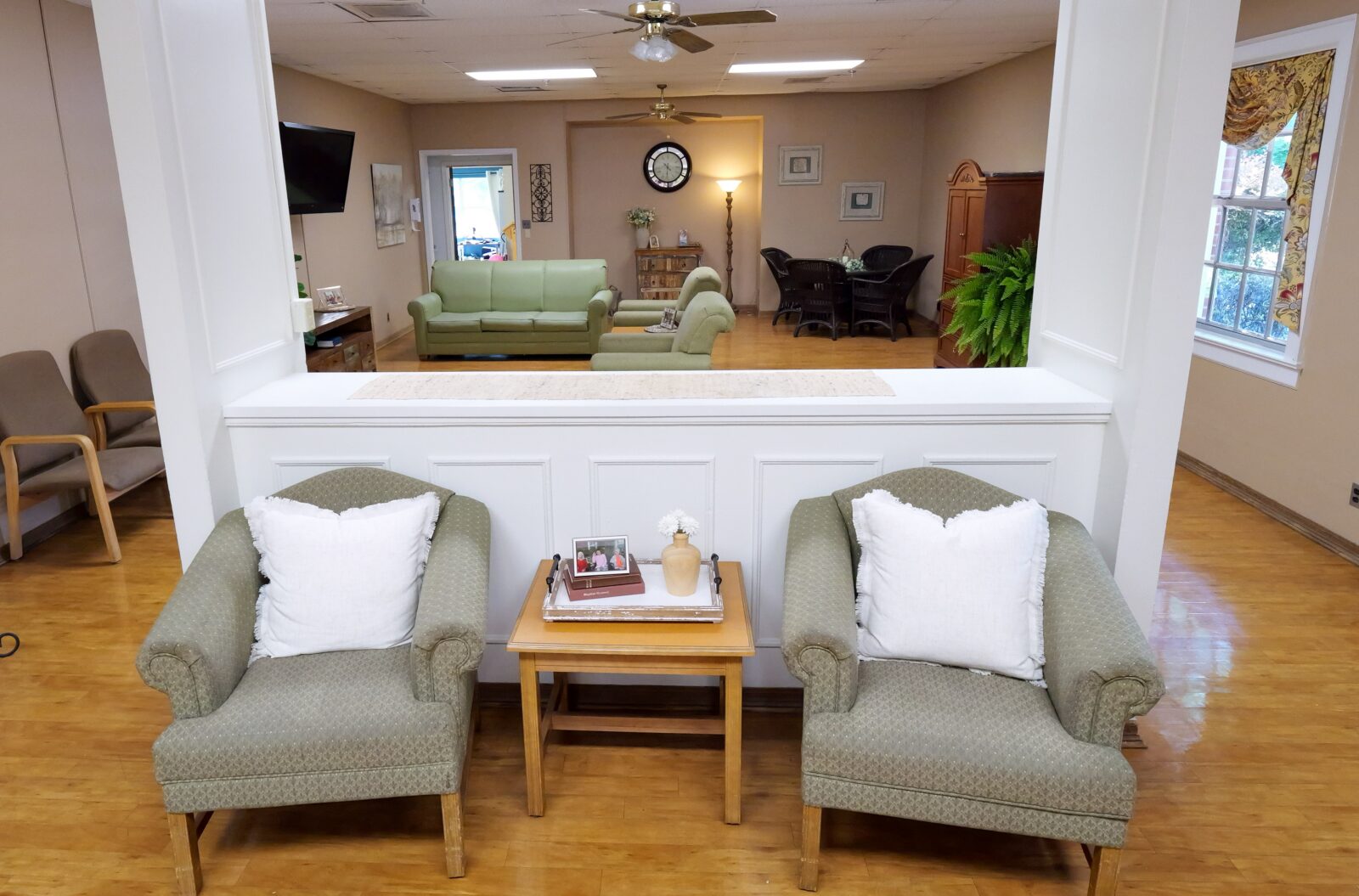 Comfortable resident lounge at a Diversicare care center with two armchairs, a small table, and a welcoming interior.