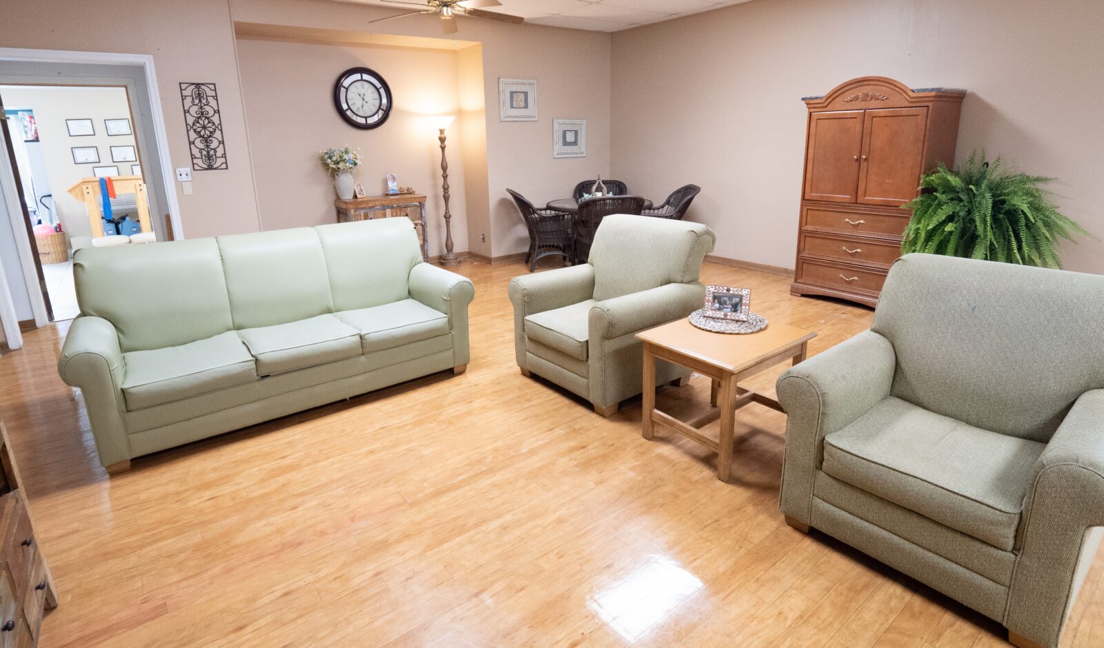 Comfortable living room at Diversicare of Tylertown featuring sofas, armchairs, and a coffee table for residents and visitors.