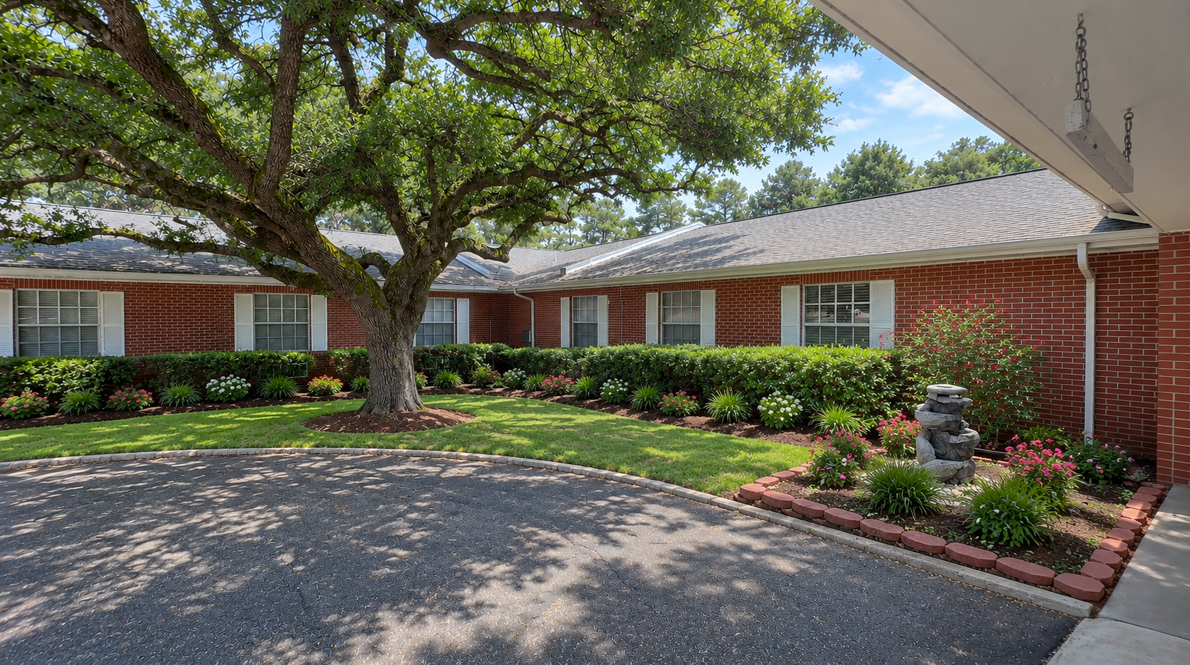 Exterior of Diversicare of Tylertown skilled nursing center featuring brick buildings, landscaped gardens, and a shaded entrance.
